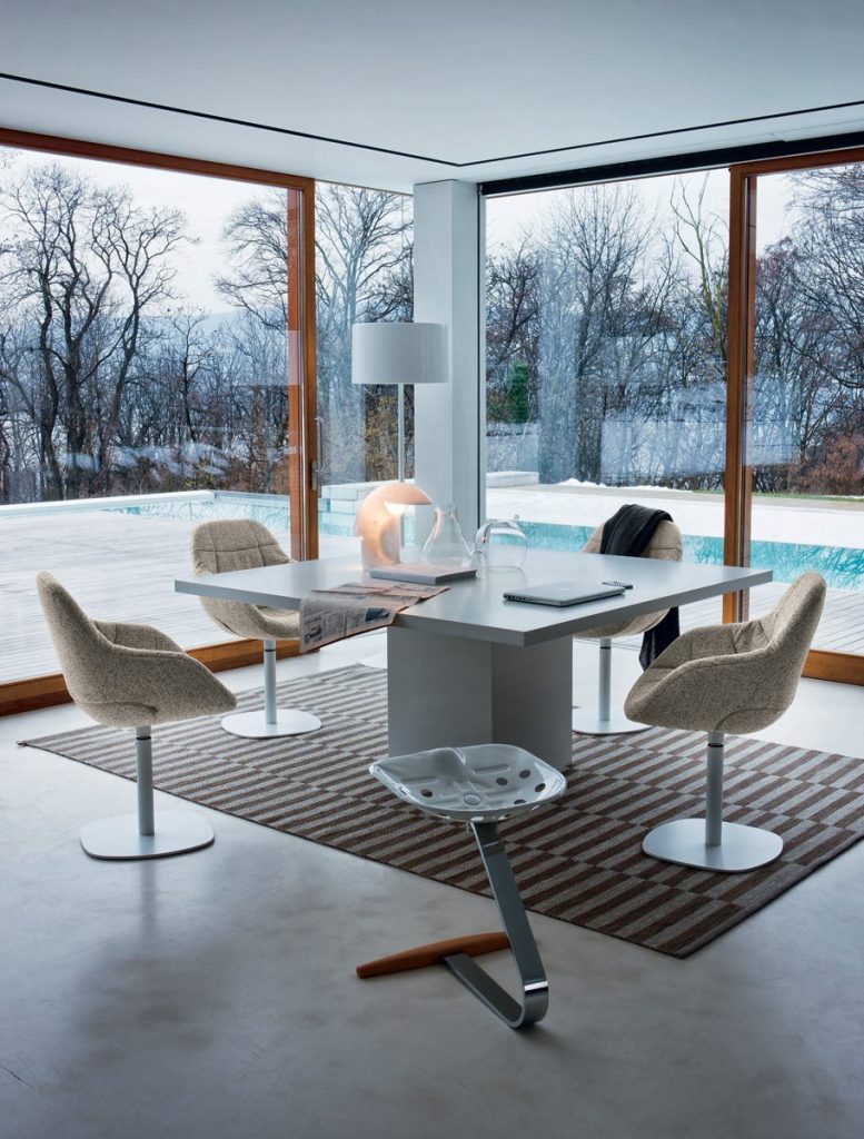 Mezzadro white stool with a unique design, featuring a red seat on a chrome base in a living room.