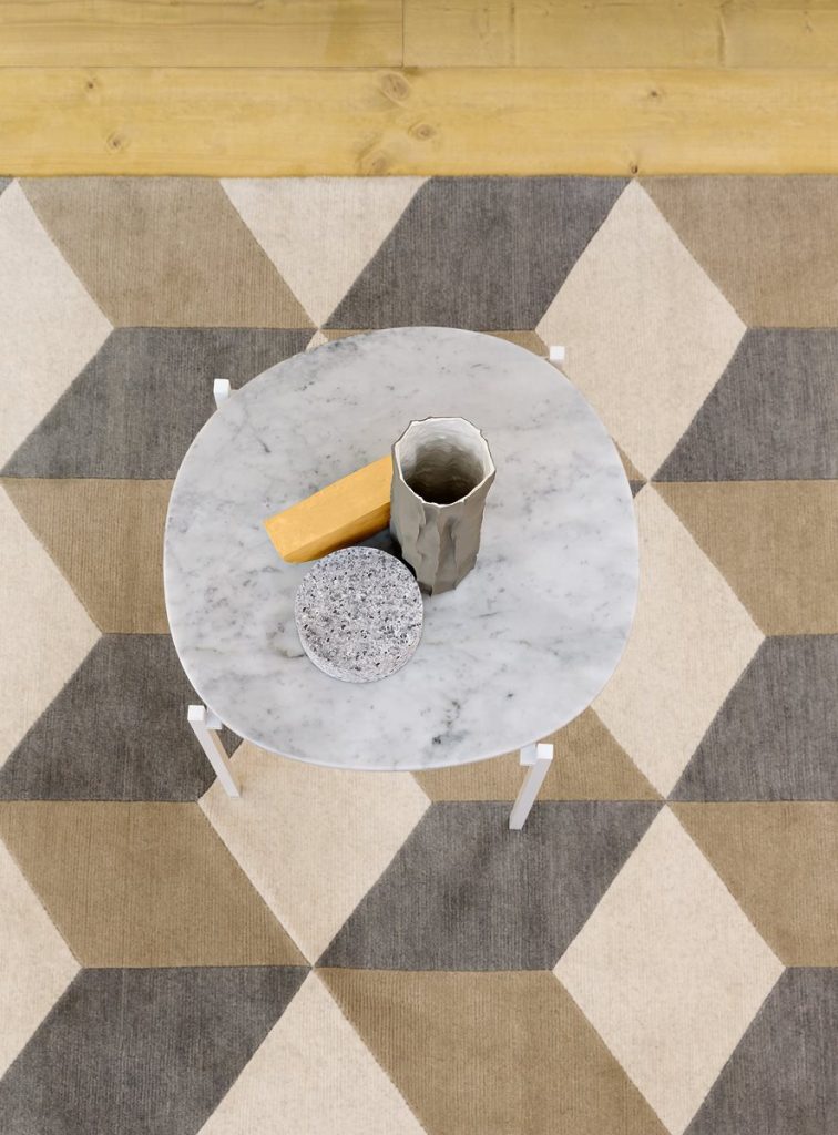 Niobe 648 coffee table with a white and gray round marble top and a white sleek metal frame on a rug.