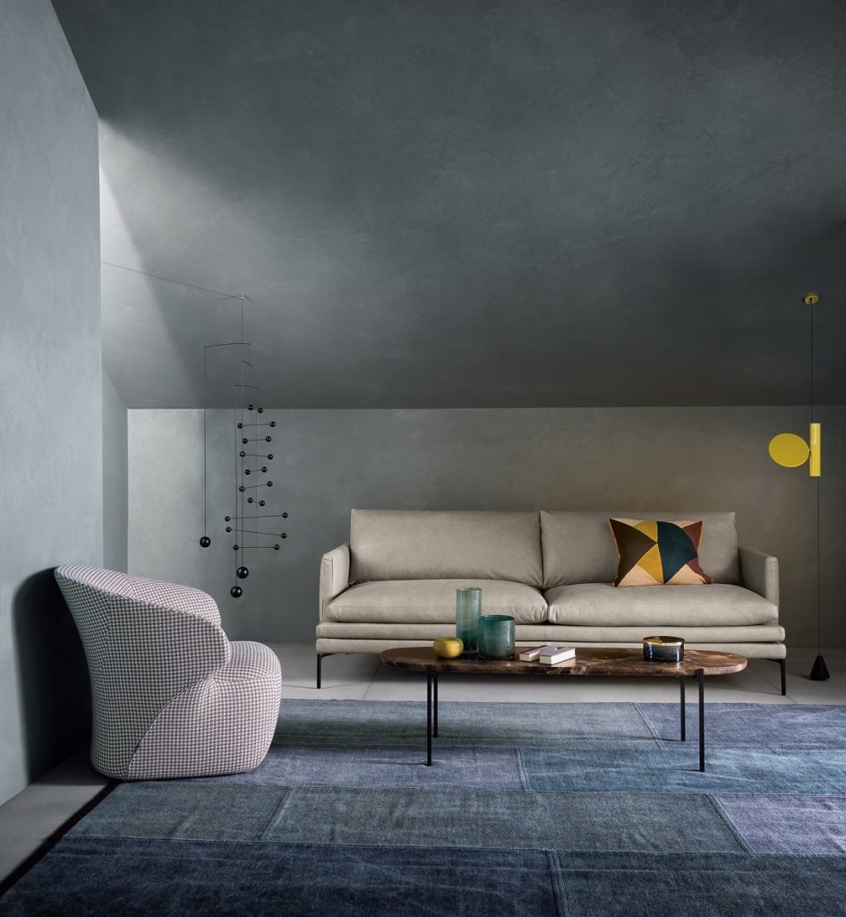 Niobe 671 672 coffee table with round top in brown and white marble, and black slender metal legs in a living room.