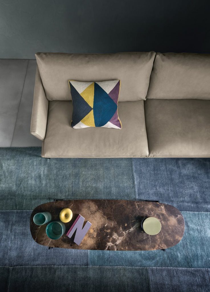 Niobe 671 672 coffee table with round top in brown and white marble, and black slender metal legs in a living room.