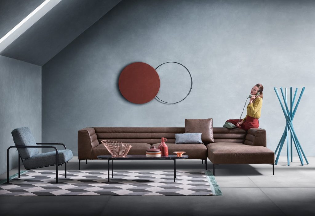 Niobe 671 672 coffee table with round top in brown and white marble, and black slender metal legs in a living room.