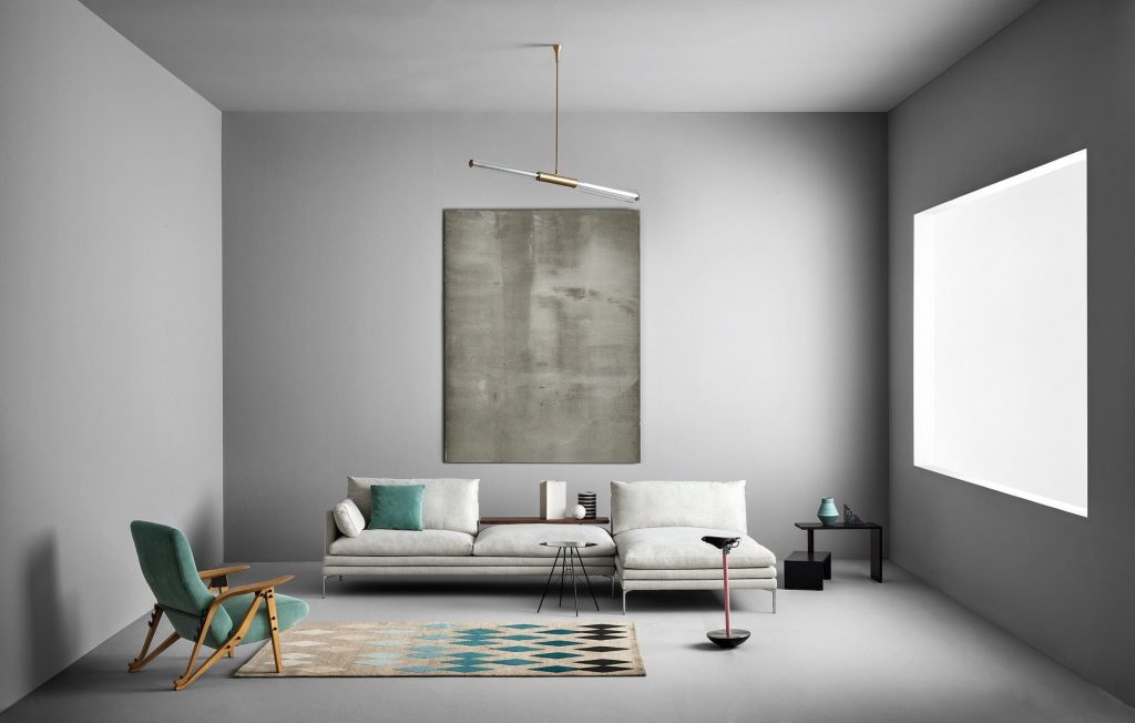 Sella stool with a unique design, featuring a black seat and a pink metal base in a living room.