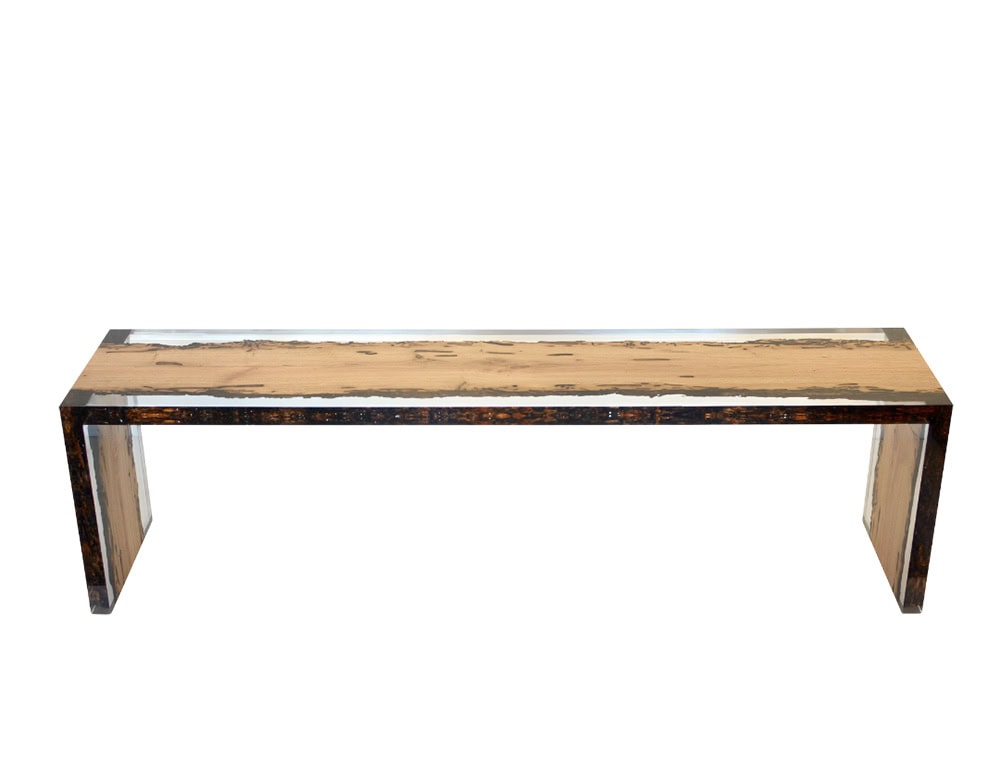 A sleek bench that merges natural wood grain with resin, creating a refined and modern silhouette. Its minimalist form highlights organic textures while providing durability and functional elegance.