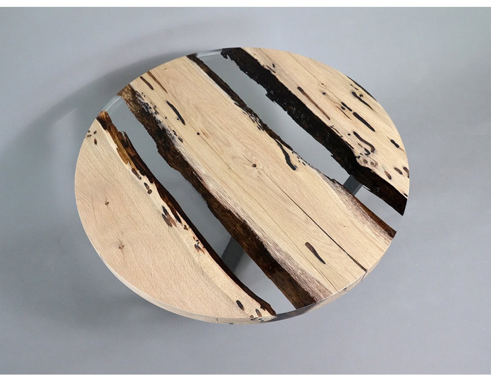 A striking round table combining natural wood slabs with crystal-clear resin. The unique voids and textures of the wood create organic patterns, while the resin surface delivers a refined, modern finish.
