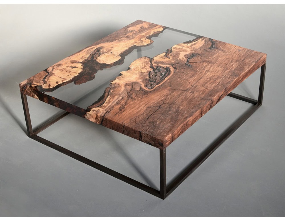 A striking low table that merges natural wood with dark resin, forming river-like patterns across the surface. Supported by a slim metal frame, it offers a balance of rustic texture and modern refinement.