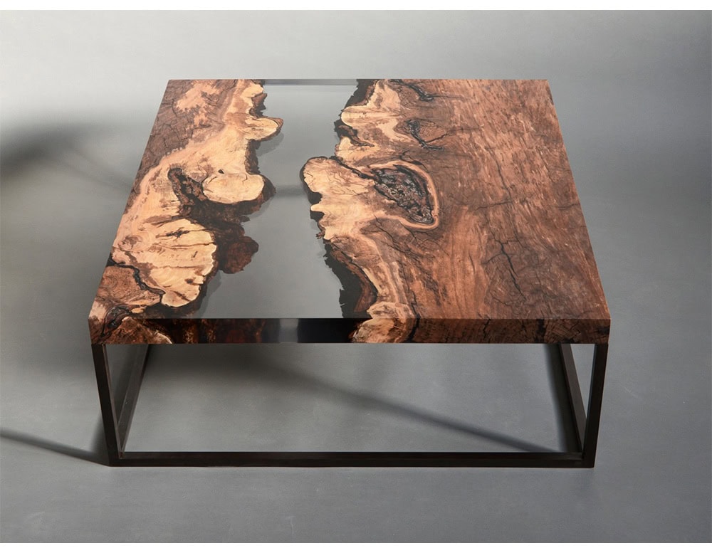 A striking low table crafted with natural wood embedded in resin, highlighting raw textures and organic patterns. Its modern structure blends rustic warmth with contemporary elegance, making it a refined centerpiece.
