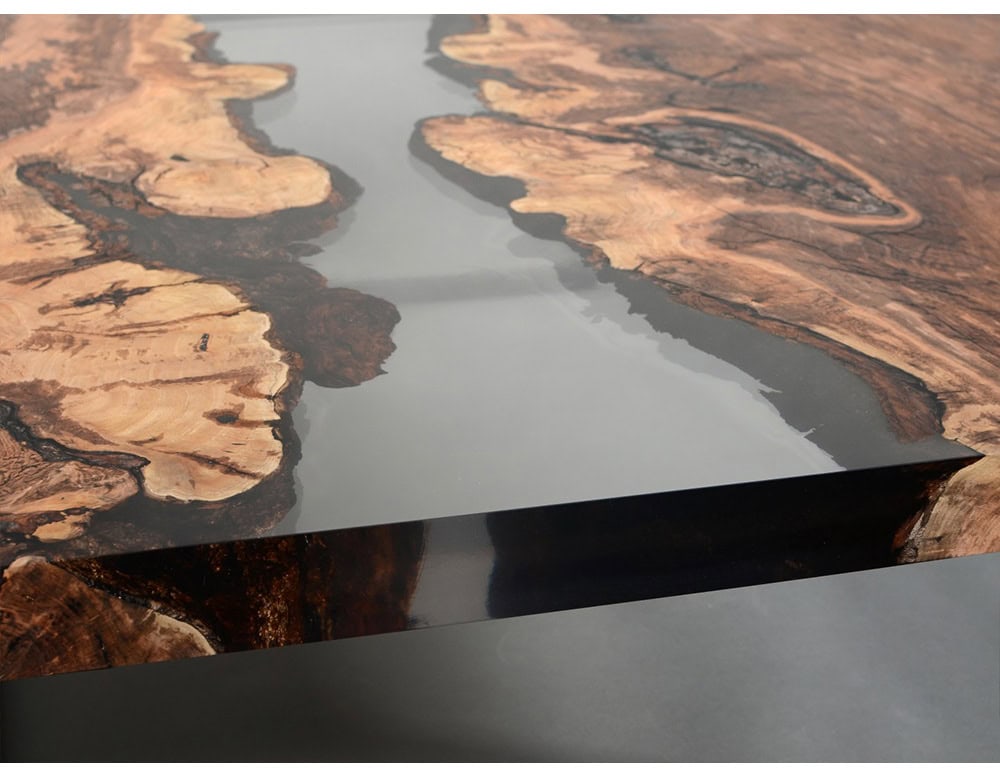 This low table blends rich wood grain with a glossy resin surface, creating the impression of flowing water framed by rugged edges. A striking centerpiece for any space.