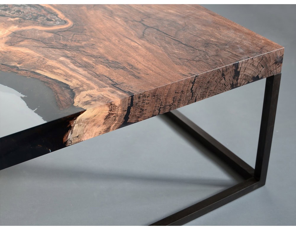 This low table showcases a striking mix of natural wood and dark resin, highlighting organic textures in a sleek, modern silhouette. A perfect statement piece blending raw beauty with contemporary design.