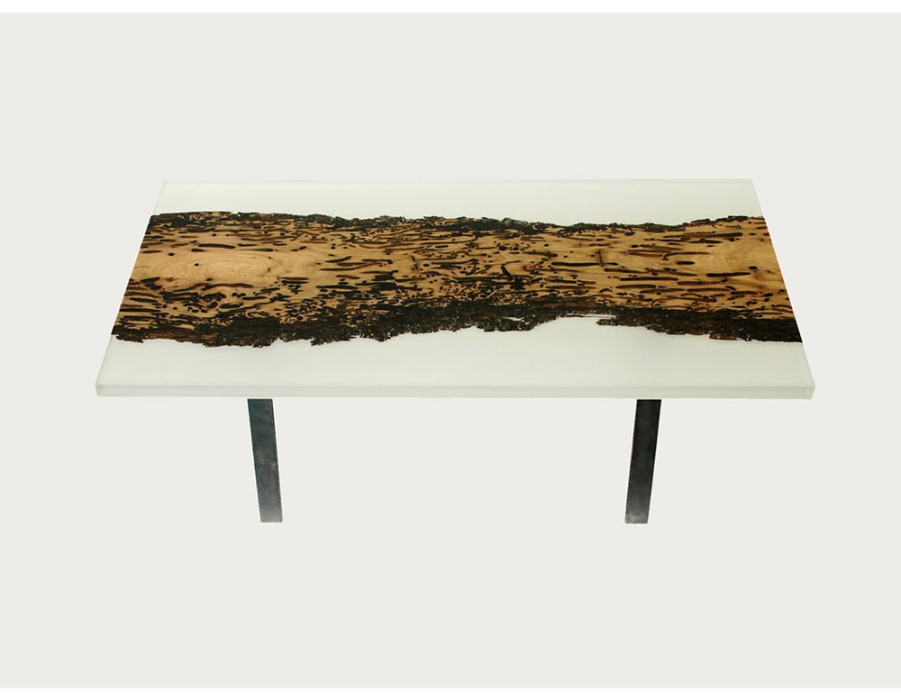 The Foggy Coffee Table blends raw wood with milky resin, creating a misty effect that emphasizes the wood’s texture. Supported by slim metal legs, it offers a modern yet organic statement for contemporary interiors.