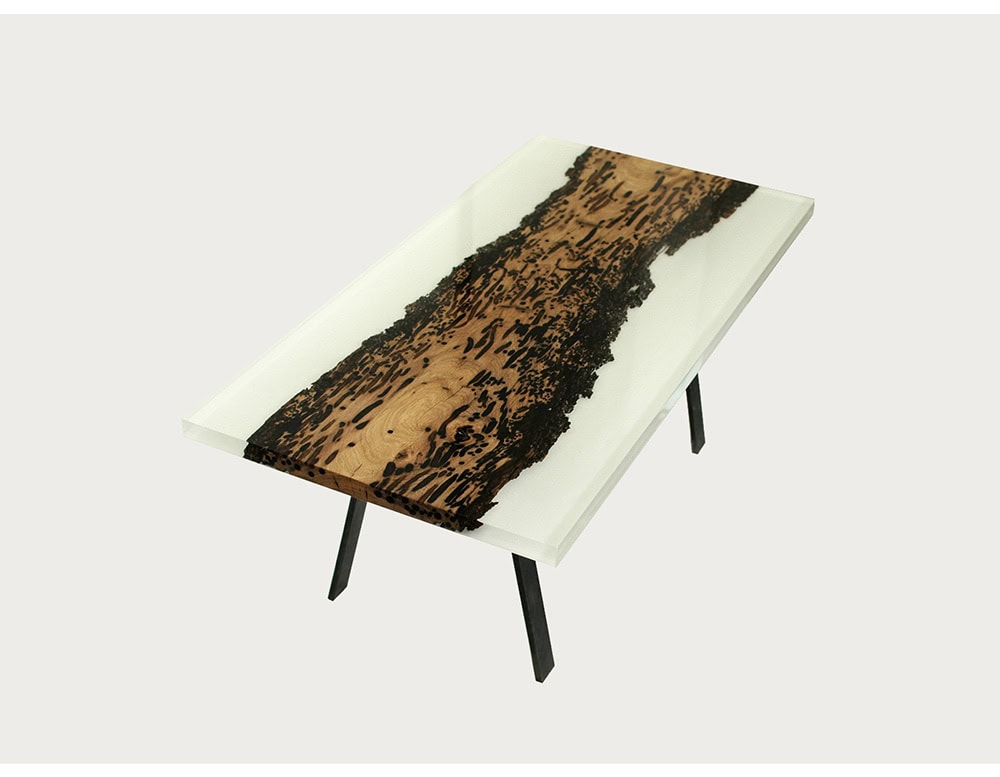 The Foggy Coffee Table combines raw wood with translucent resin, creating a mist-like effect that highlights natural textures. Its minimalist metal legs complete the design with a refined balance of elegance and stability.