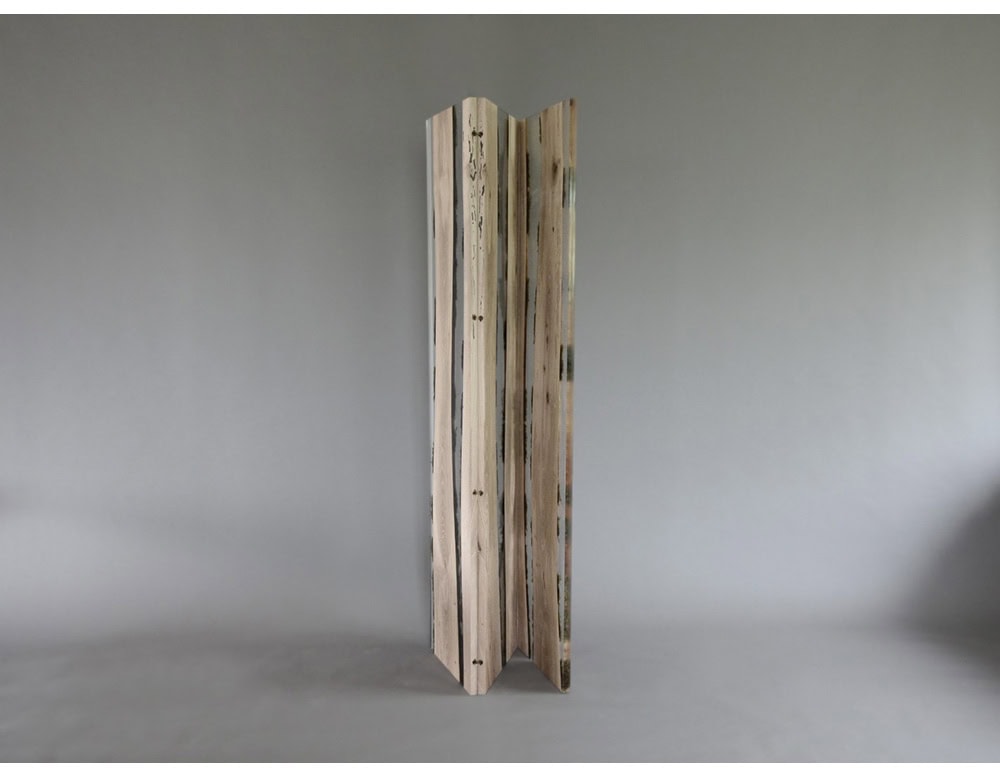 Moss Screen features vertical wood planks encased in resin, preserving raw textures and natural details. Its translucent build interacts with light, creating a sculptural element that is both functional and decorative.