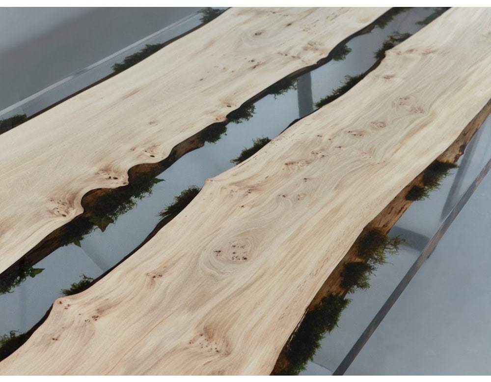 The Moss Table combines natural oak wood with embedded moss in resin, creating the effect of a flowing landscape captured in furniture. Its organic edges and sleek base merge raw beauty with refined modern design.