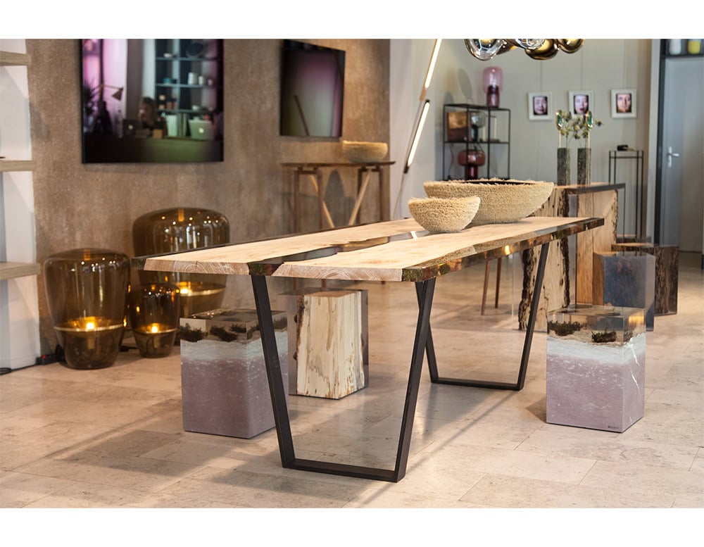 The Moss Table combines natural oak wood and preserved moss encased in resin, creating a striking balance between organic textures and sleek transparency. Its steel base enhances the table’s modern yet earthy aesthetic.