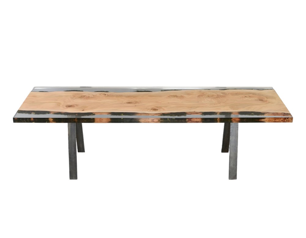 Moss Table features a smooth wood surface with rich grain encased in transparent resin, accented by natural moss elements. Supported by solid legs, it embodies a balance of organic materiality and modern craftsmanship.