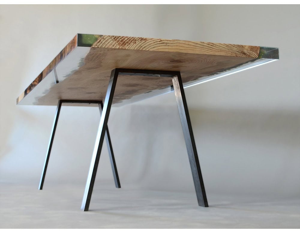 A striking single plank moss table blending natural wood with embedded greenery and resin, supported by sleek metal legs for a modern organic look.
