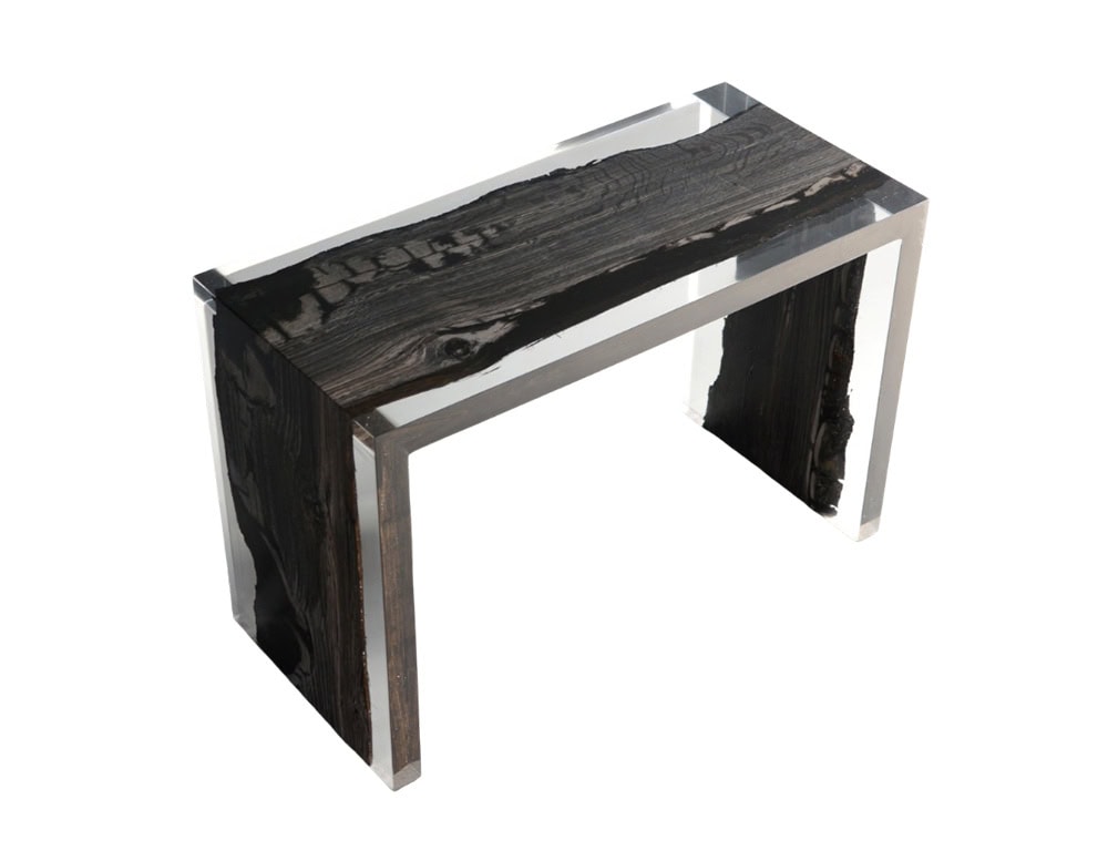 A striking bench combining dark preserved wood with transparent resin, creating a modern design that highlights the natural textures of aged timber.