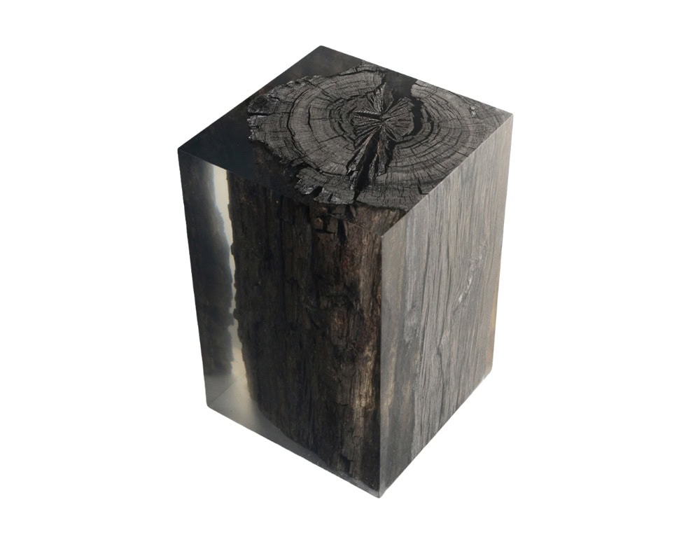 Handcrafted stool featuring ancient peatland wood preserved in crystal clear resin. The natural textures of the wood contrast with the polished geometric form, creating a striking functional art piece.