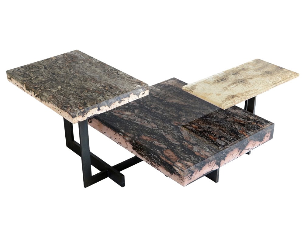 Phellem Low Table features layered cork tops in varied tones, arranged at different heights on slim metal legs. Its sculptural composition blends natural texture with a modern architectural feel.