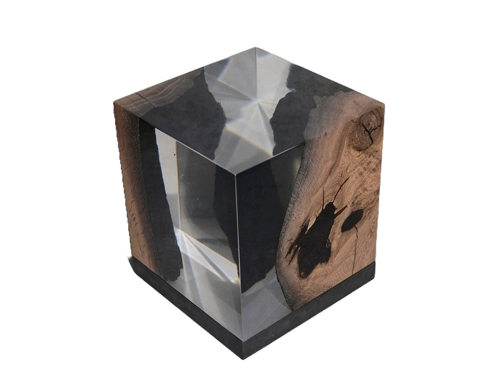 Wetland Lamp is a cubic piece combining dark wood and clear resin that captures light with prismatic reflections. Its raw inclusions highlight natural textures, turning it into both a lamp and sculptural object.
