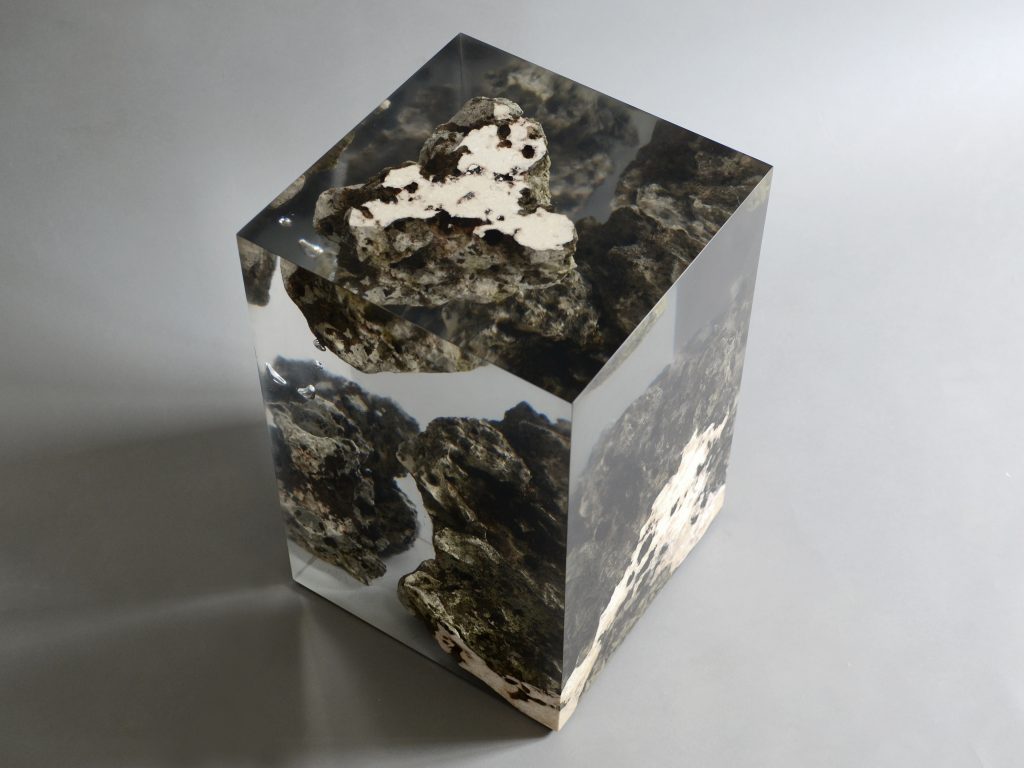Floating Karst Stool/Side Table with a geometric design, made of natural stone with a transparent resin inlay, set against a gray background.