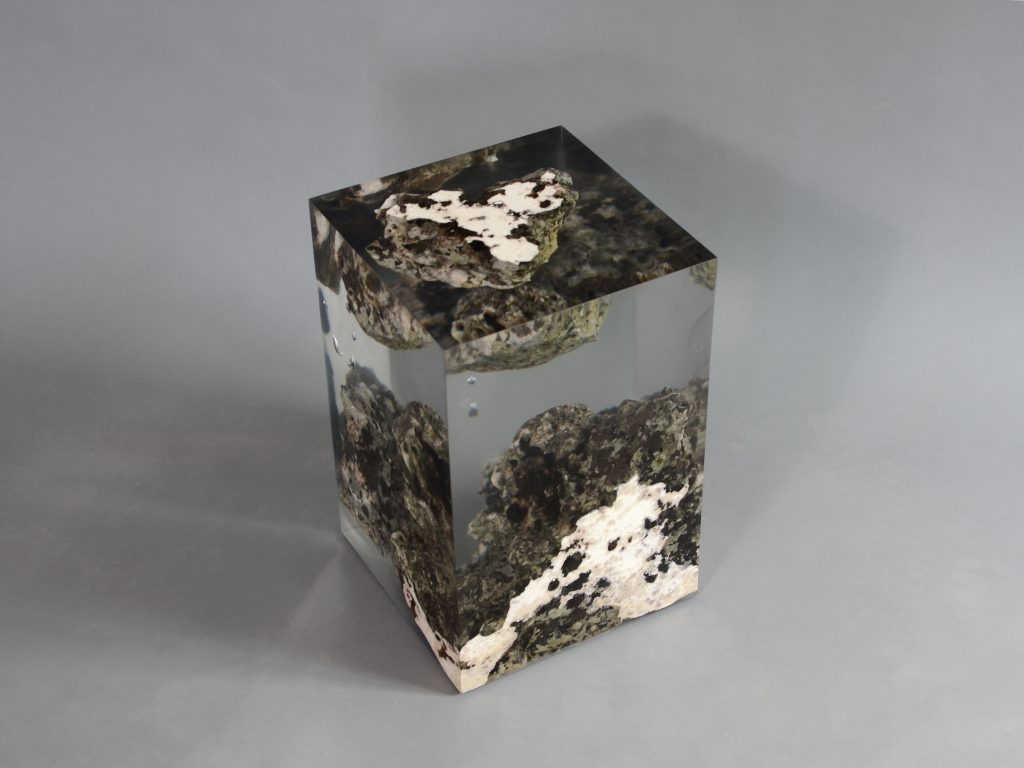 Floating Karst Stool/Side Table with a geometric design, made of natural stone with a transparent resin inlay, set against a gray background.