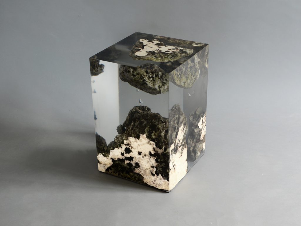 Floating Karst Stool/Side Table with a geometric design, made of natural stone with a transparent resin inlay, set against a gray background.