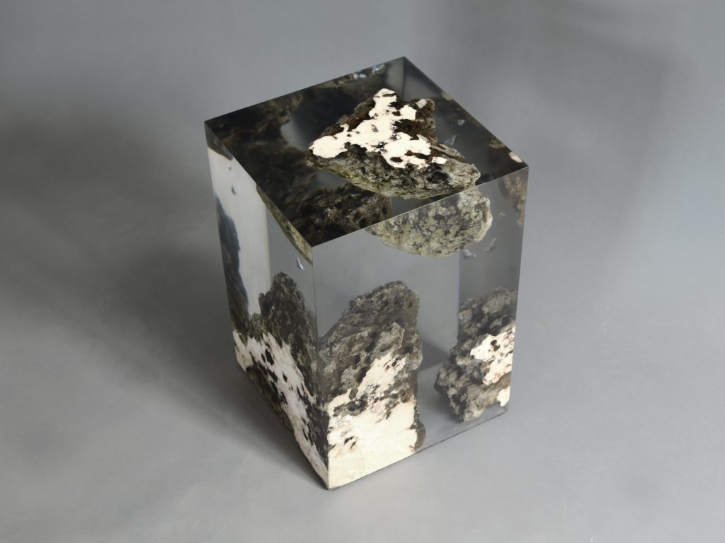 Floating Karst Stool/Side Table with a geometric design, made of natural stone with a transparent resin inlay, set against a gray background.