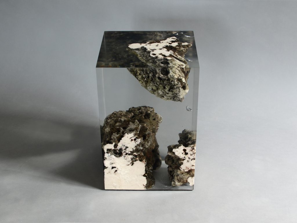 Floating Karst Stool/Side Table with a geometric design, made of natural stone with a transparent resin inlay, set against a gray background.