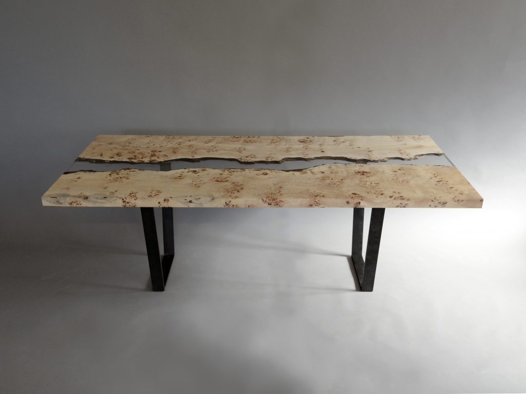 table made of two-tone wood base and resin coated in half on a gray gray background