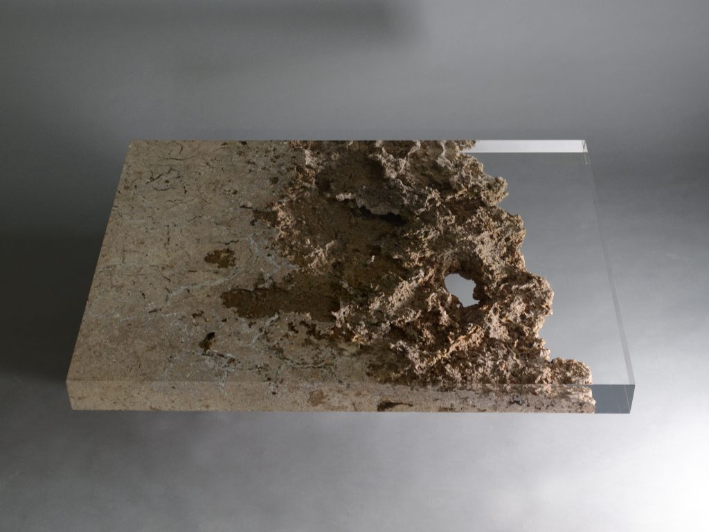 small plate made of natural stone and transparent glass in a brown tone on a gray background