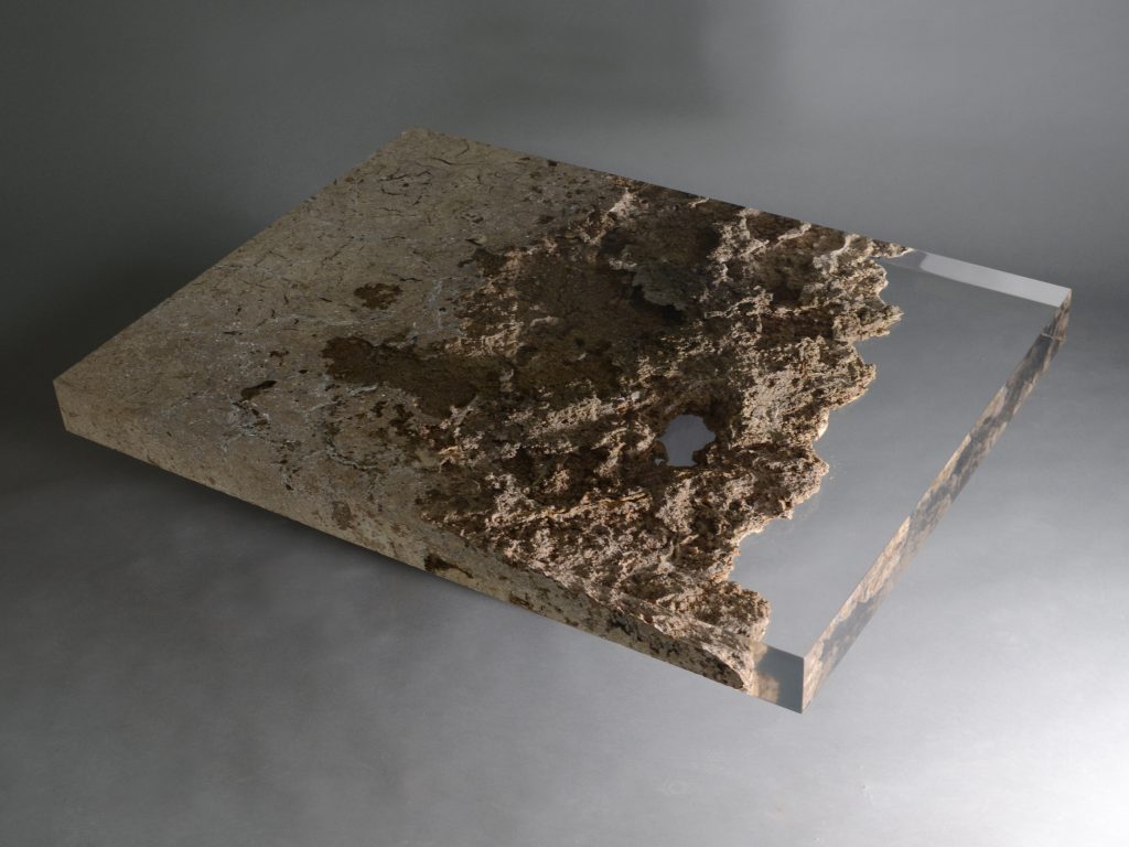 small plate made of natural stone and transparent glass in a brown tone on a gray background