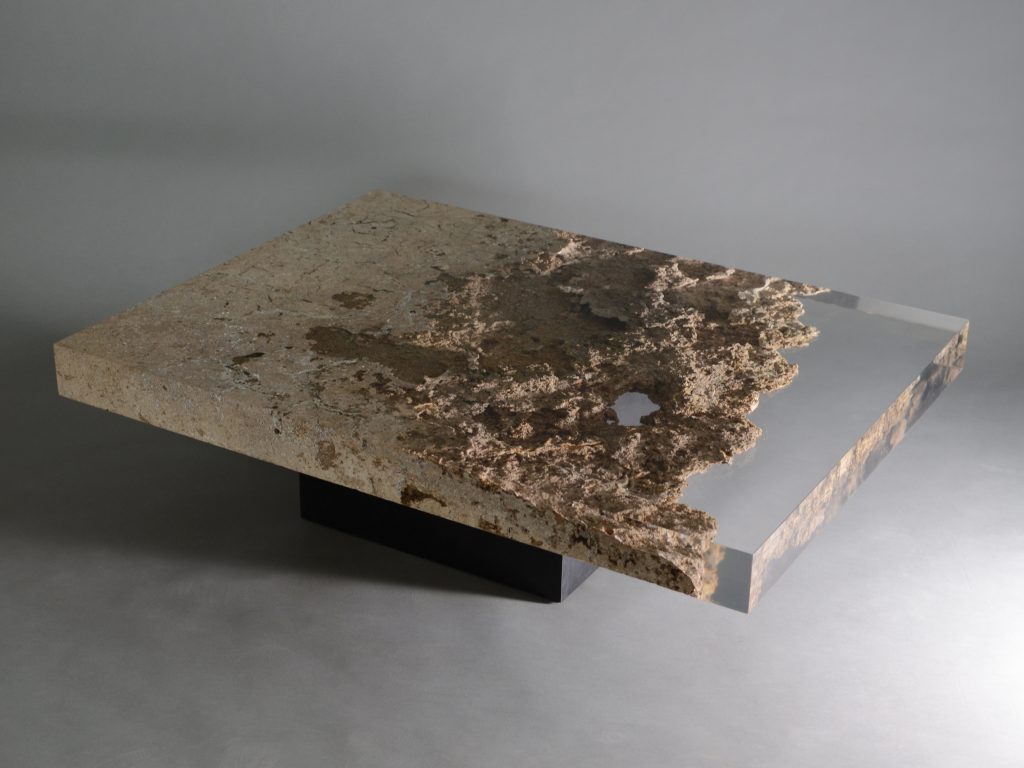 small plate made of natural stone and transparent glass in a brown tone on a gray background