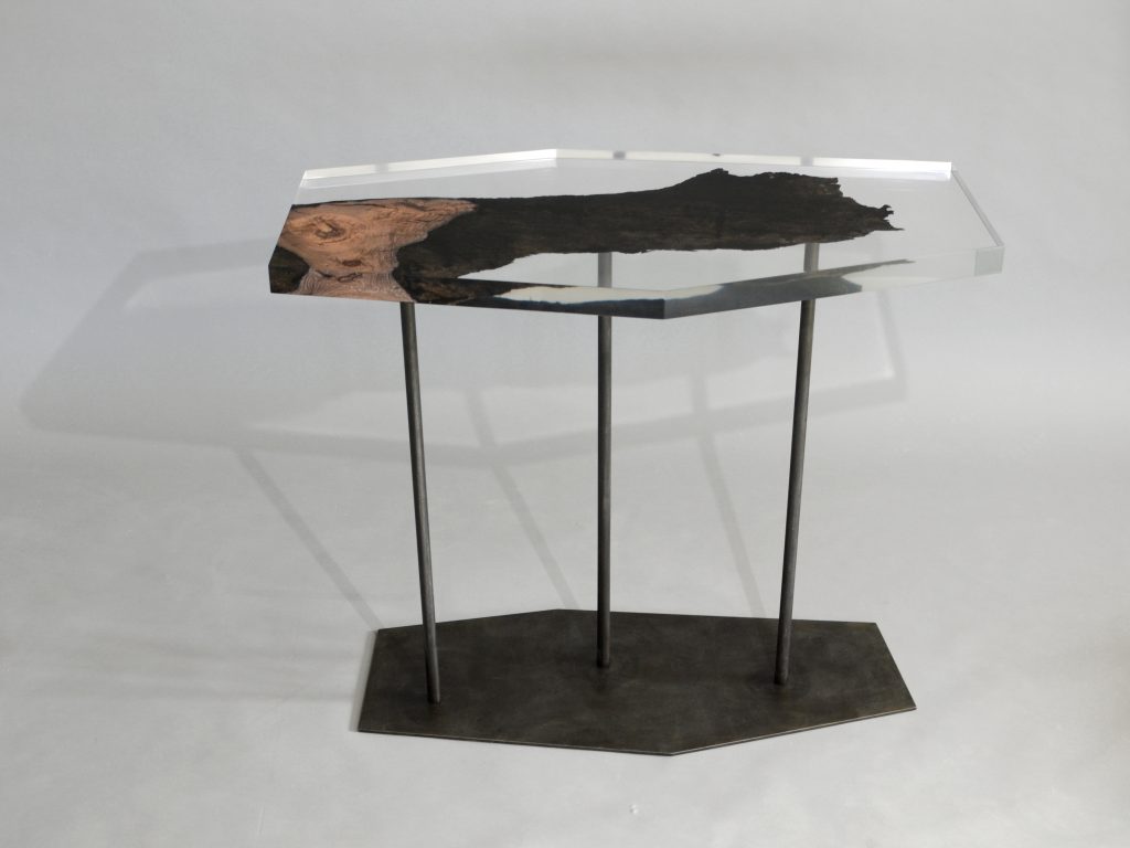 table made of resin and natural wood in the shape of a hexagon resting on a base of steel legs