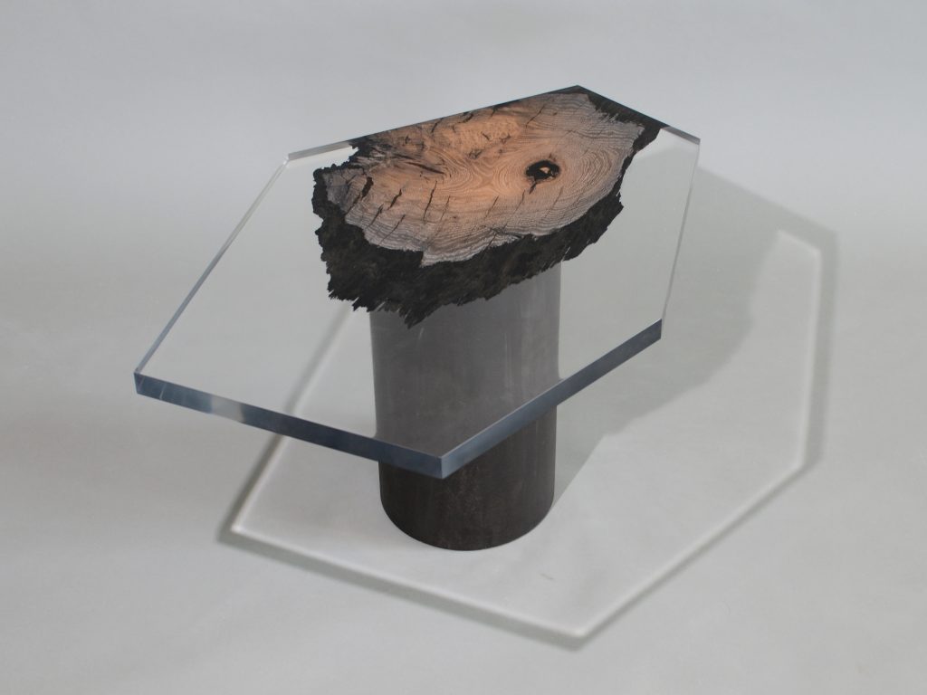 side table made of a brown wooden log and thick transparent glass top in the shape of a hexagon