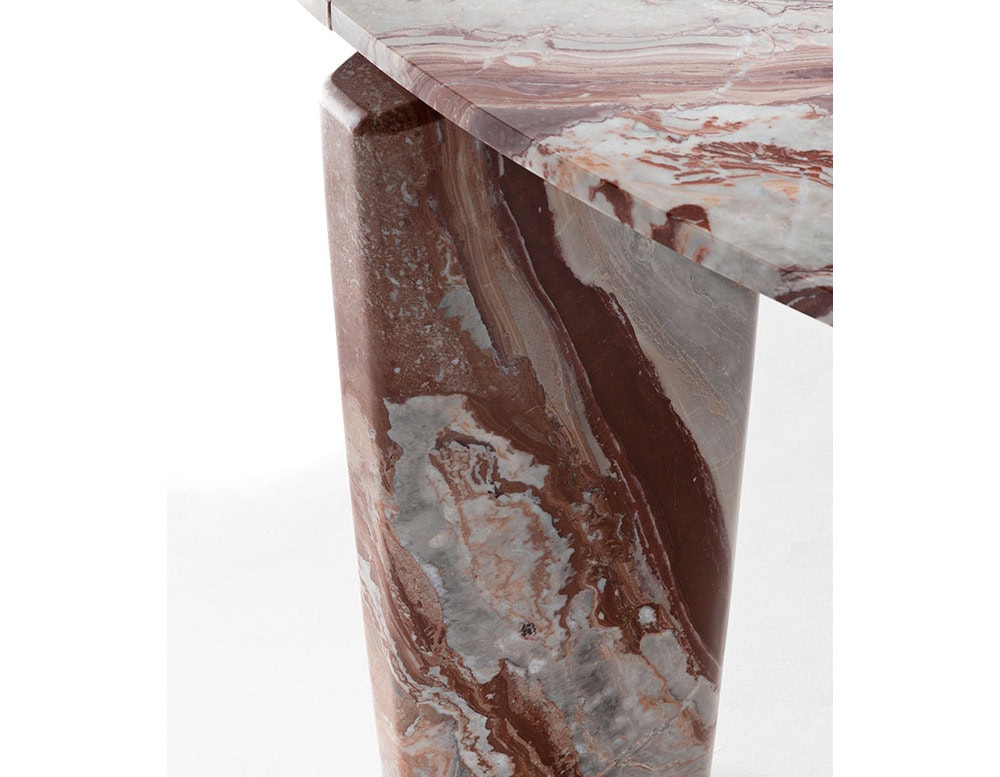 A close-up of a Giotto Outdoor Dining Table shows a leg with a swirling pattern of brown and gray marble against a white background