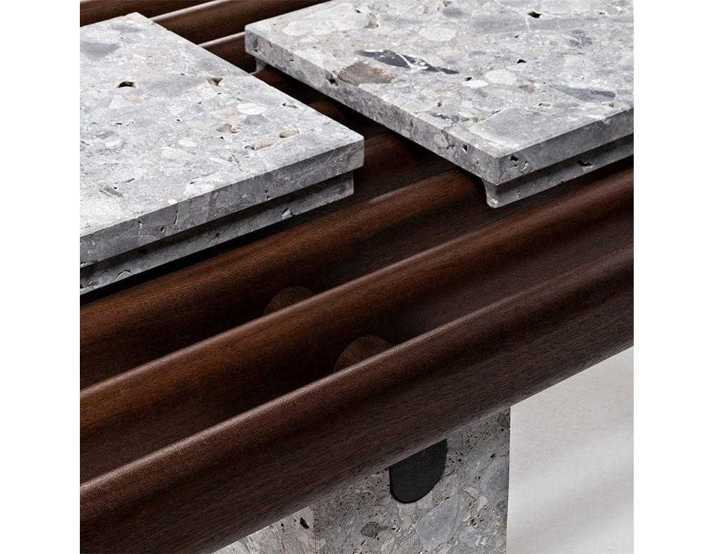 Closeup of Panarea Coffee Table. Upper part made of brown wooden sticks and lower part is a block of yellow stone on a white background.