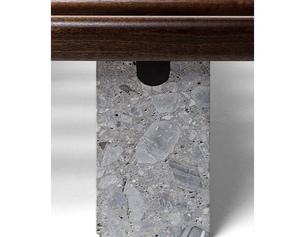 Closeup of Panarea Coffee Table. Upper part made of brown wooden sticks and lower part is a block of yellow stone on a white background.