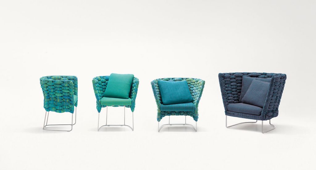 Four blue Ami Indoor Chairs, structure upholstery of woven fabric, seat cushion of fabric, structure and leg in steel on a white background.