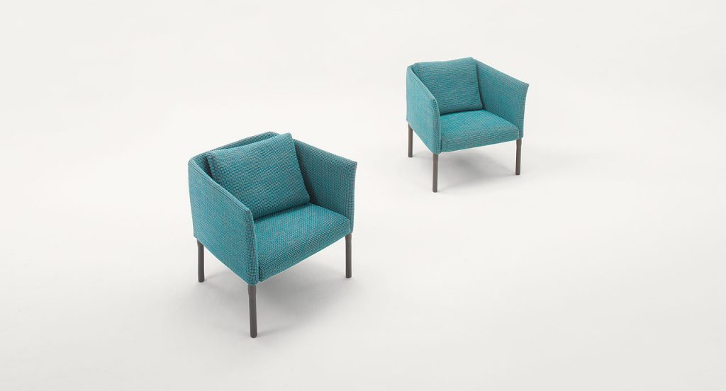 Two Elsie Armchairs, four wooden legs, upholstery in blue on a white background.