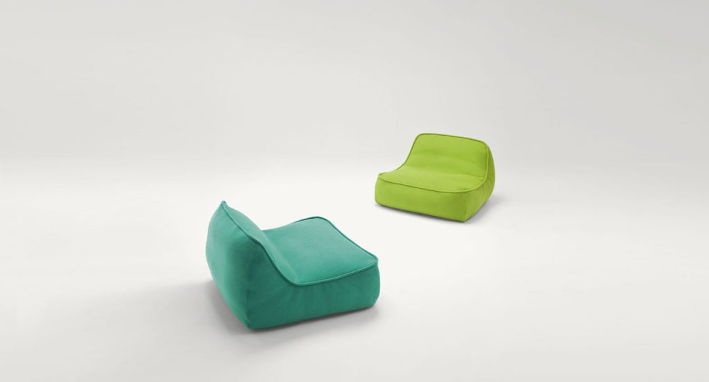Two Float-Float mini easy chairs, upholstey in spaced fabric, one in green and one in blue on a white background.