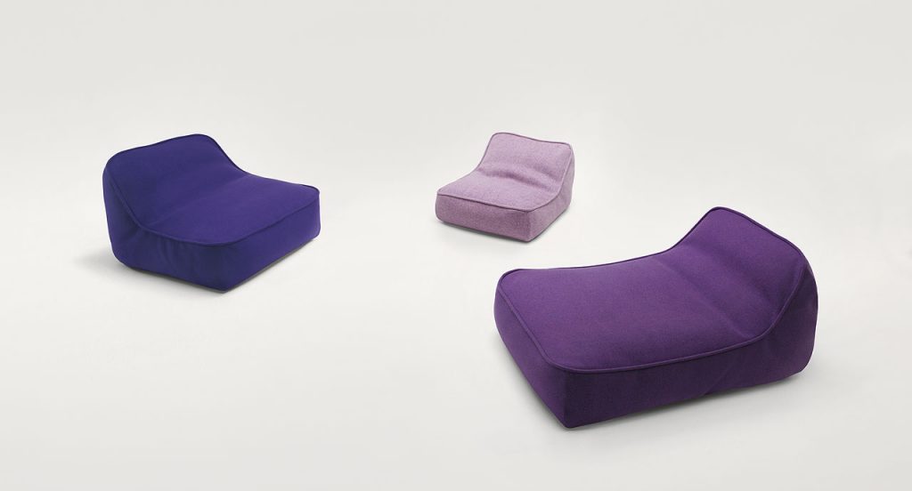 Three Float-Float mini easy chairs, upholstey in spaced fabric, one in purple on a white background.