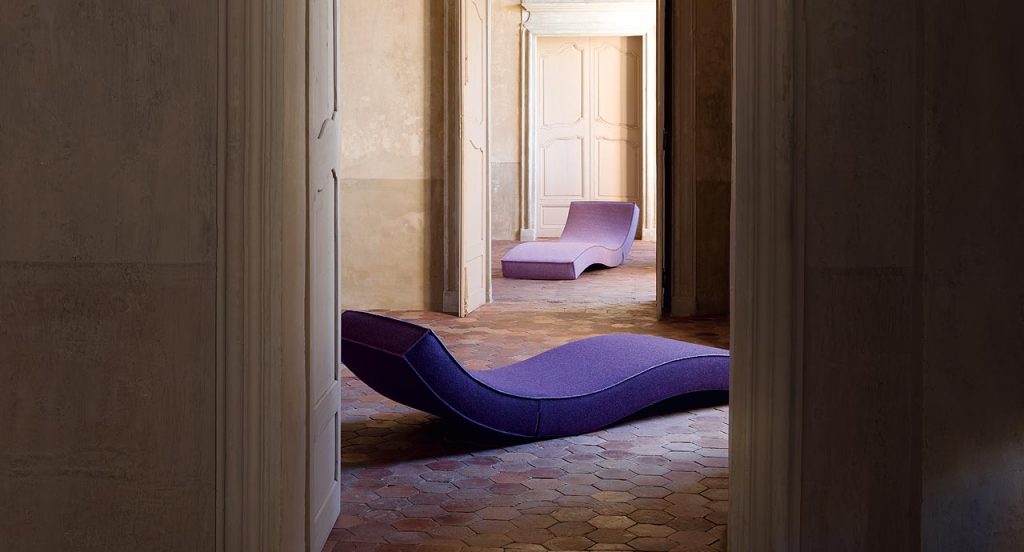 Two Linea chaise longue, upholstery in purple fabric in a living room.