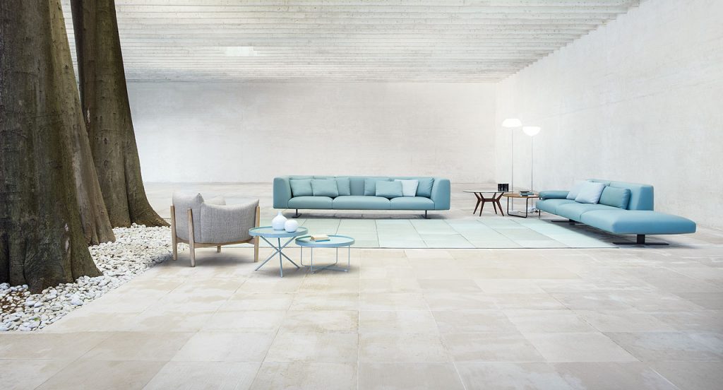 Two blue Flip side tables, round top and three legs in steel in a living room.