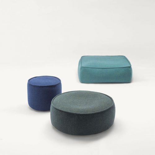 Three Float Indoor Poufs, upholstered in blue fabrics, one square and two round on a white background.