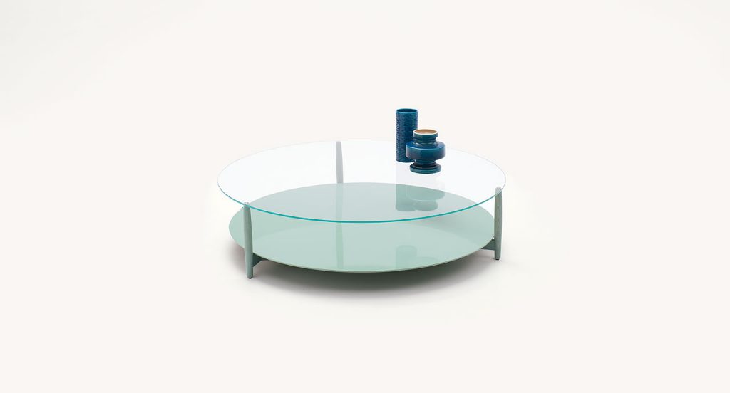 Harvey side table, base and legs in blue heartwood, lower surface in in blue fiber, top in transparent glass on a white background.