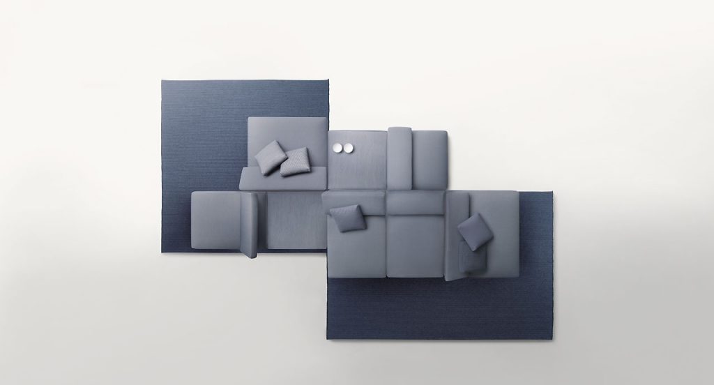Agio Modular sofa composed of large platforms, backrest can be adjusted, all upholstered in gray fabric on a white and blue background.