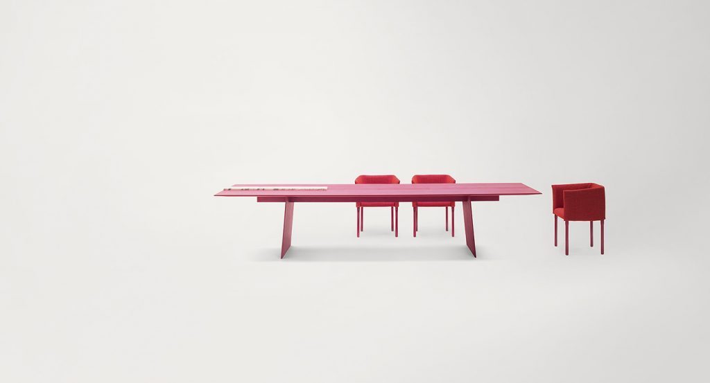 Pink Kanji Dining Table, top in fibreboard and two legs in wood and two white metal trays on a white background.