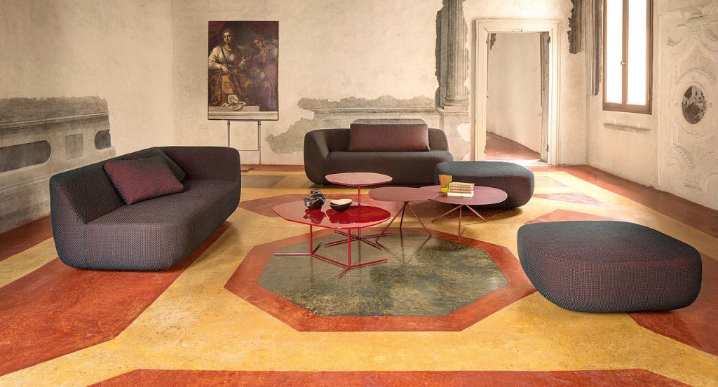 Three Lever Indoor Coffee Tables, top in yellow and central leg in red steel in a living room.
