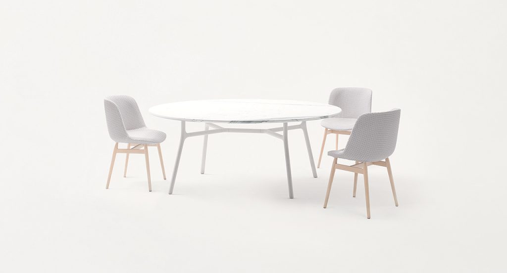 Nesso Indoor Dining Table, white wooden top, four legs structure in white aluminium in a dining room.