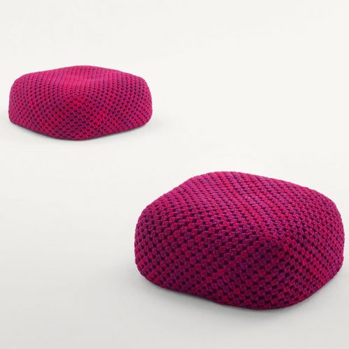 Two Berry poufs made of pink woven upholstery on a white background.